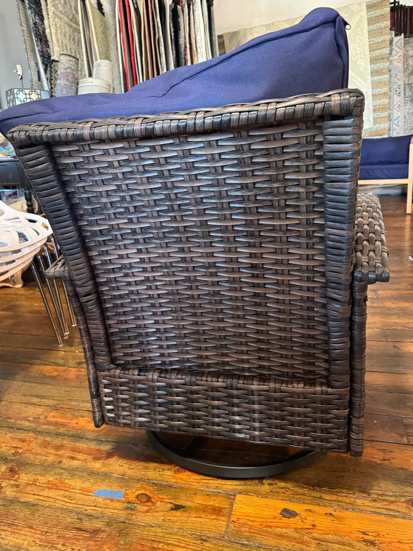 Brown wicker outdoor swivel chair with navy cushion 🔷
