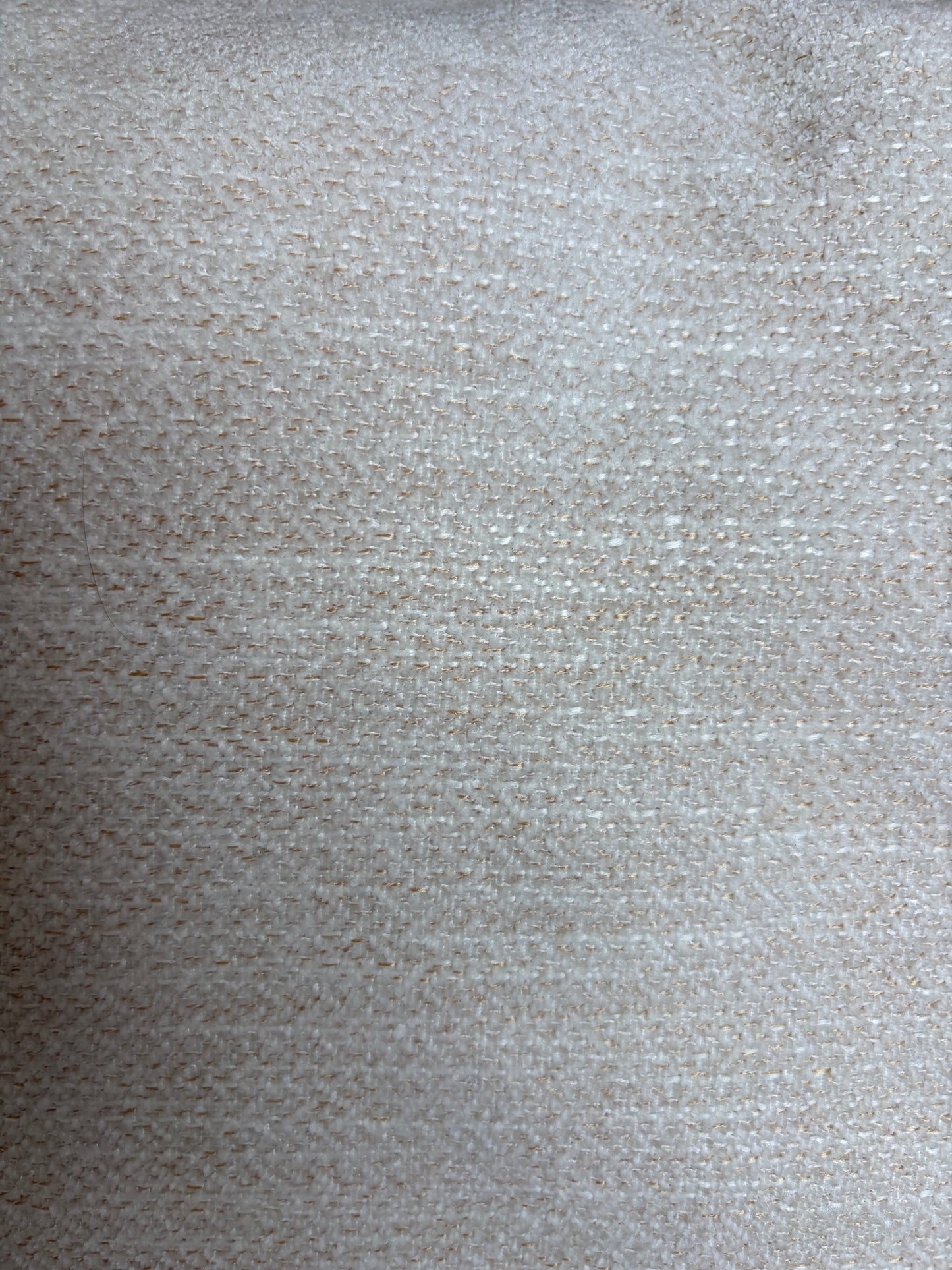 A close-up of a textured fabric or material swatch in a warm off-white, beige tone with subtle woven detail.