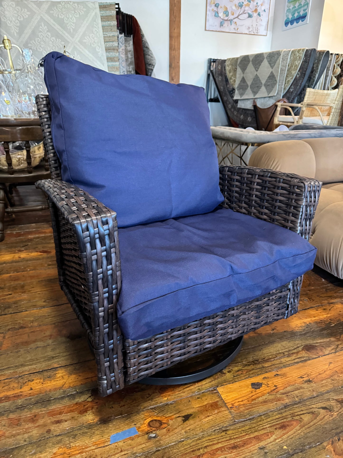 Brown wicker outdoor swivel chair with navy cushion 🔷